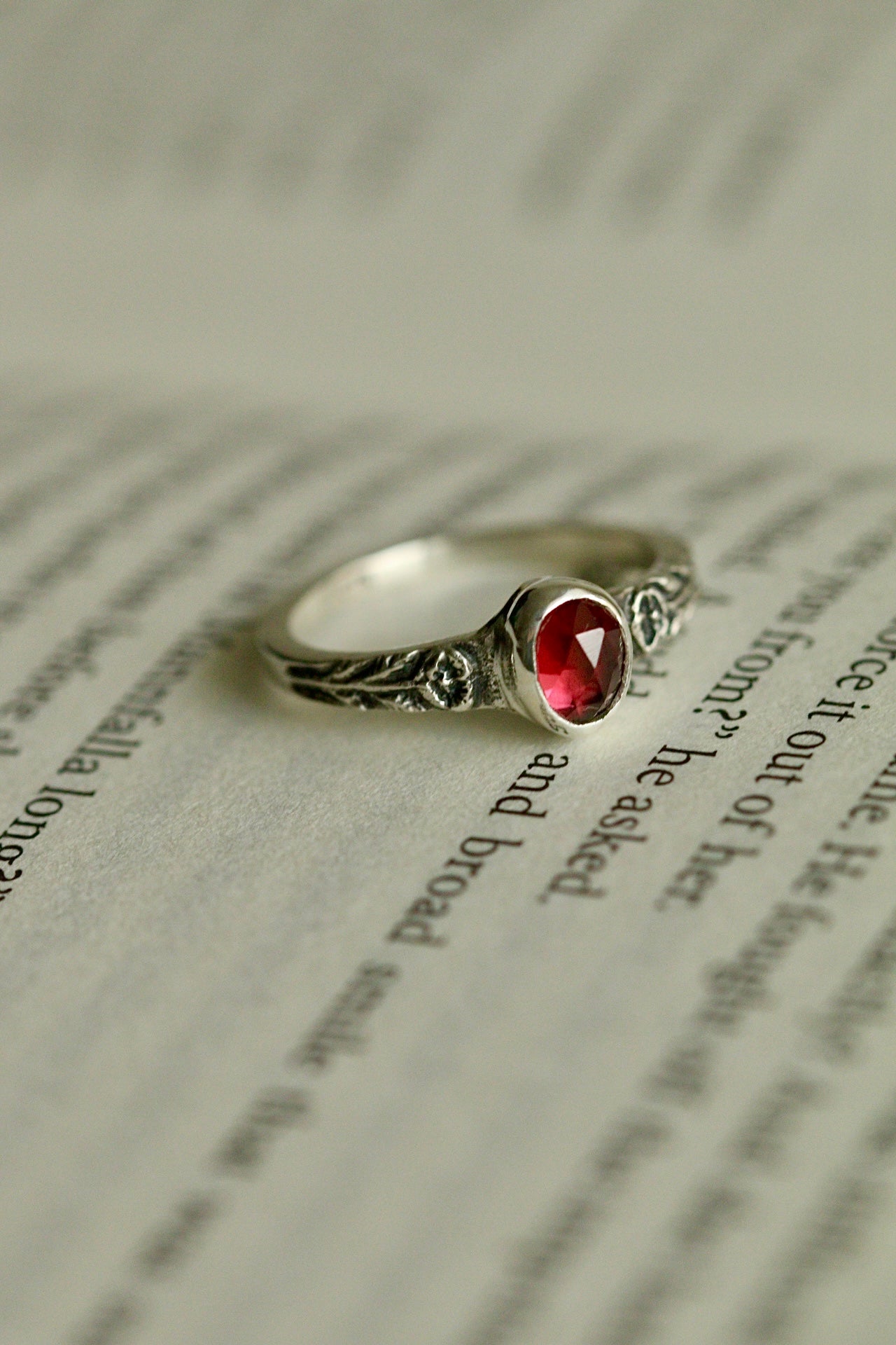 Silver poppy ring with bezel set garnet