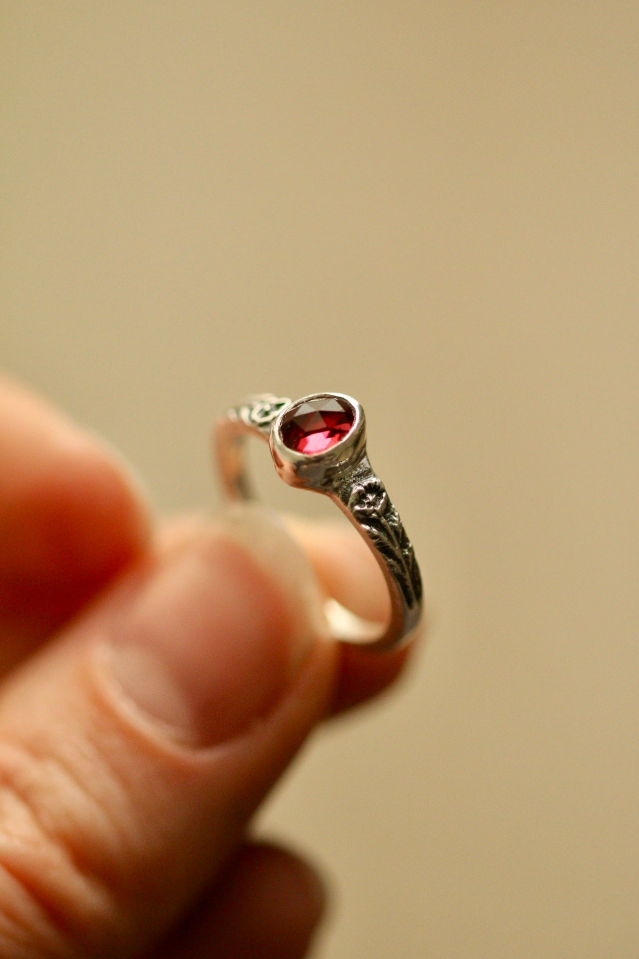 Silver poppy ring with bezel set garnet