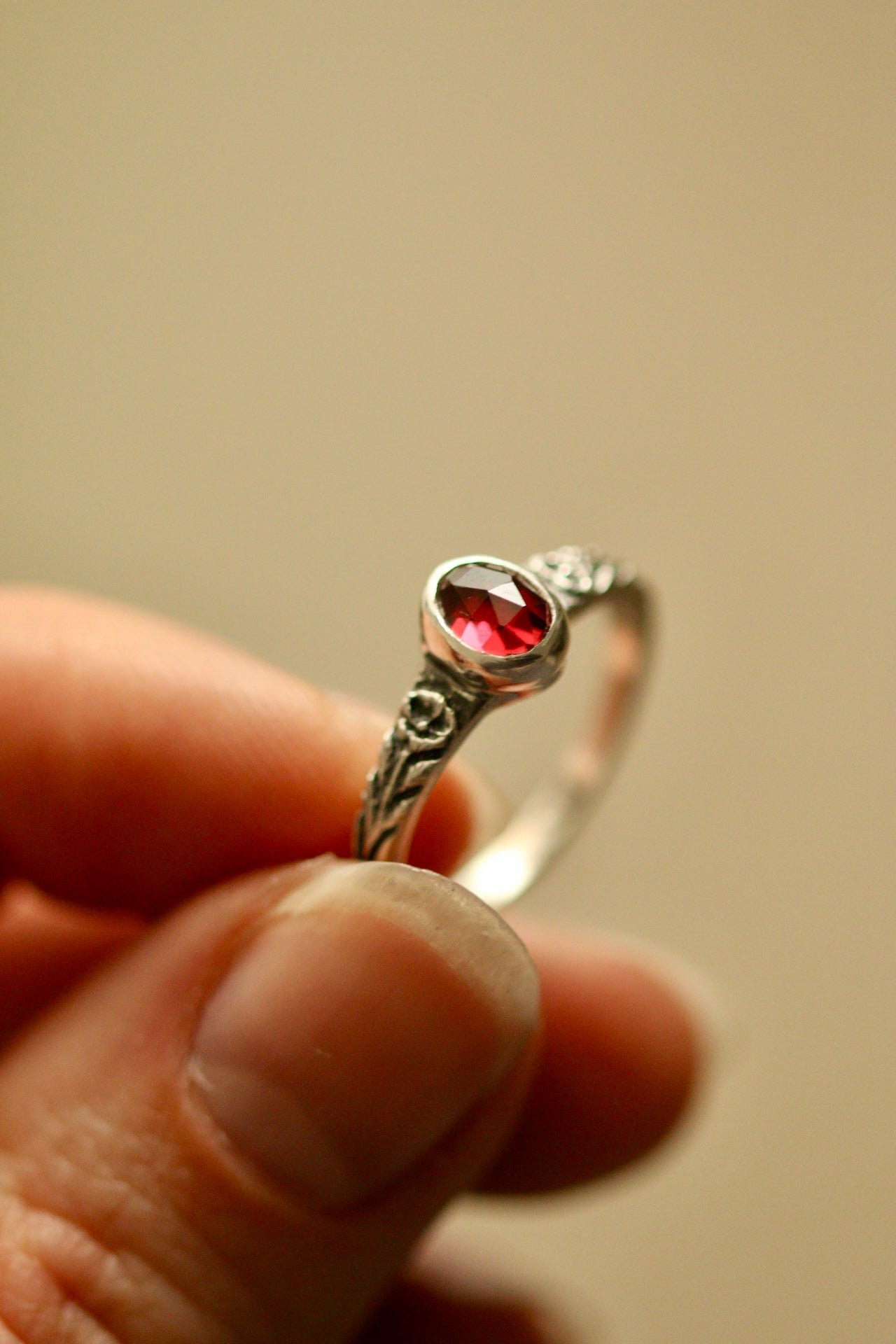 Silver poppy ring with bezel set garnet