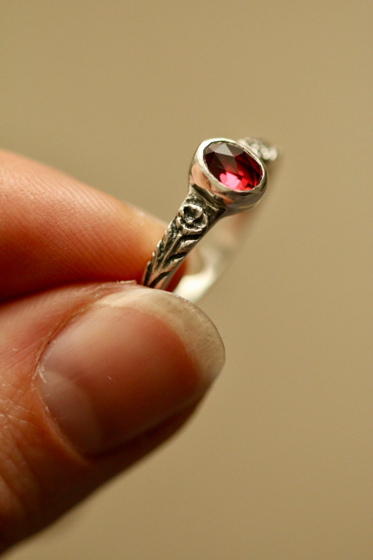 Silver poppy ring with bezel set garnet
