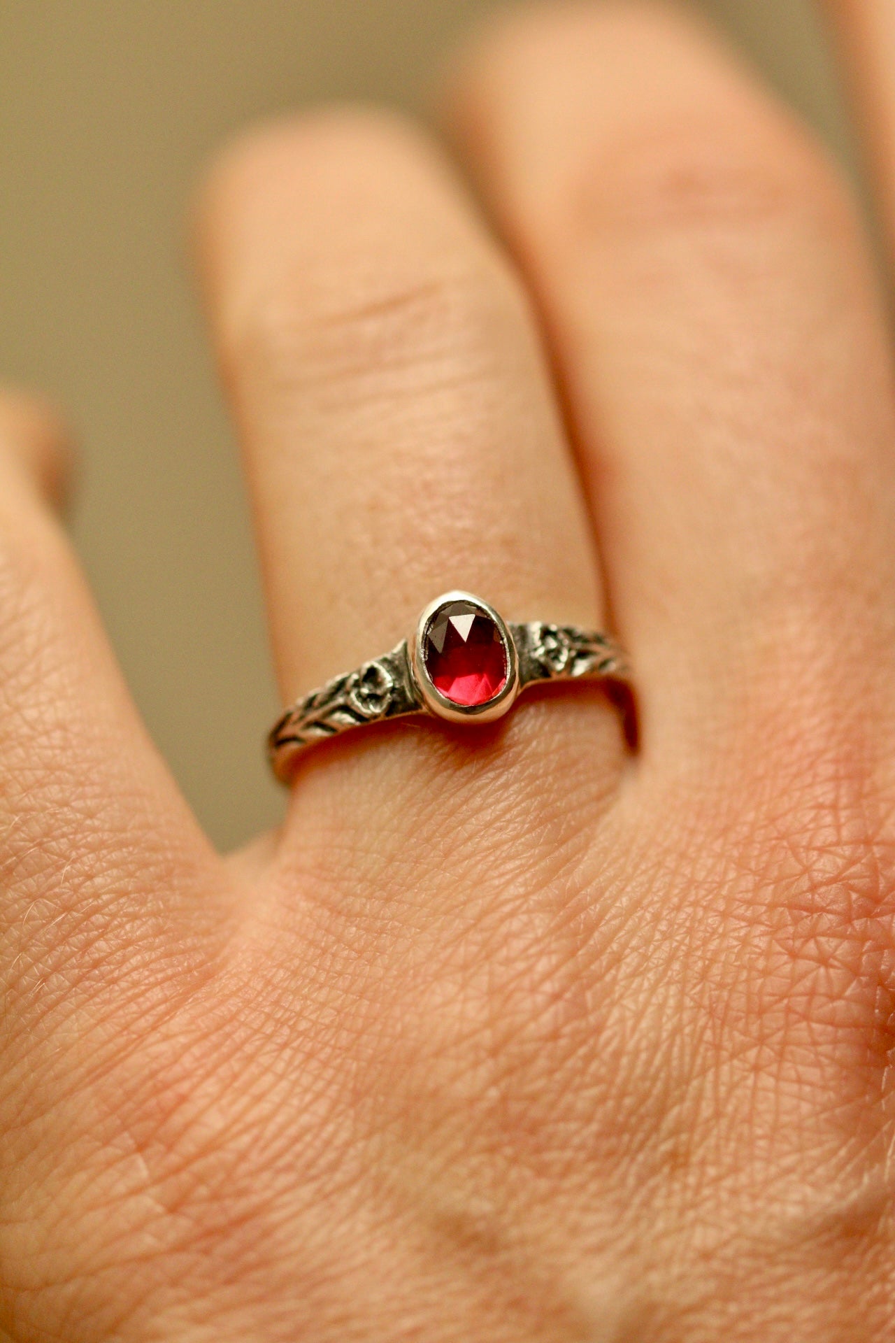Silver poppy ring with bezel set garnet