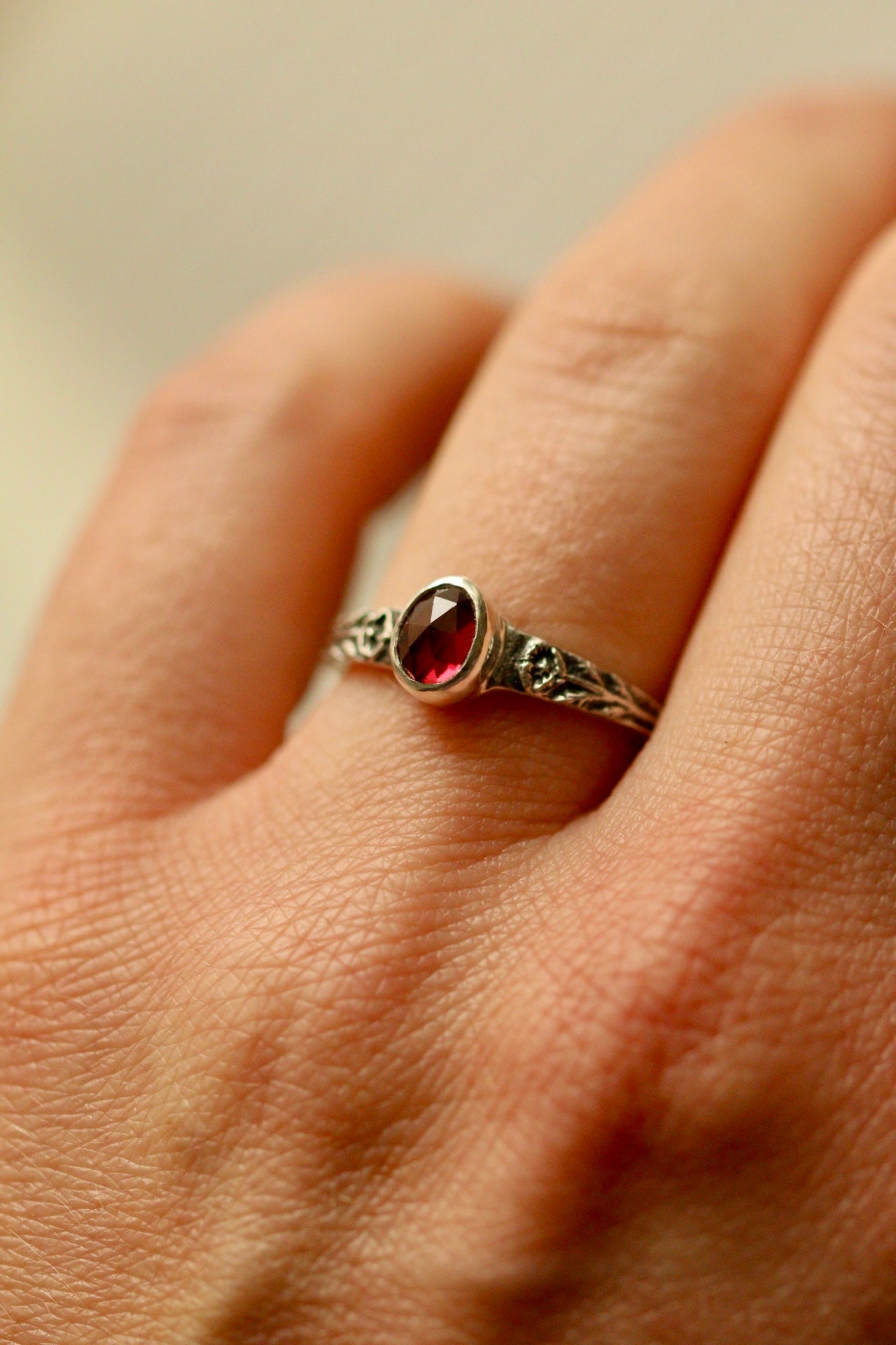 Silver poppy ring with bezel set garnet