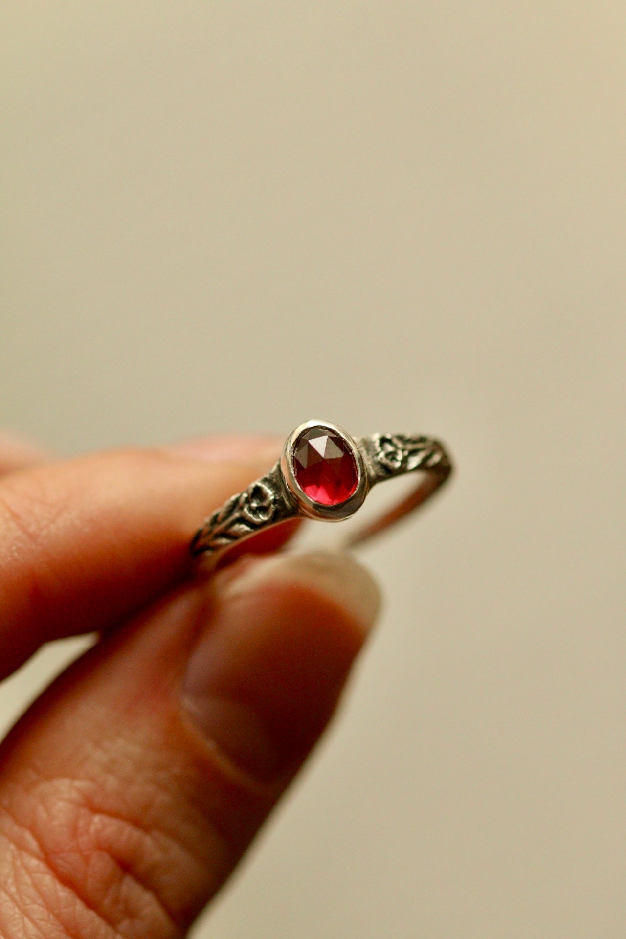 Silver poppy ring with bezel set garnet